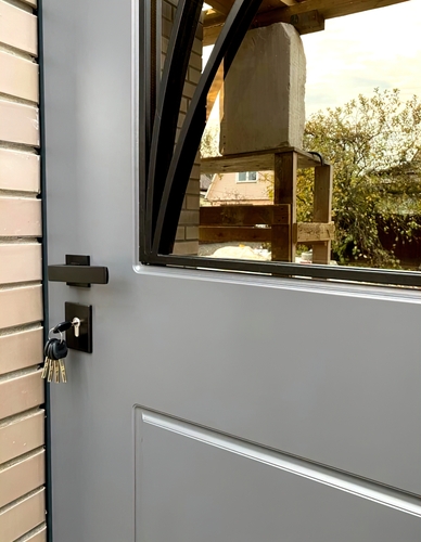 Серая дверь окрашенная по RAL со стеклопакетом и решеткой